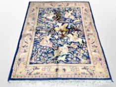 A machine made Indian rug depicting figures hunting on horseback,