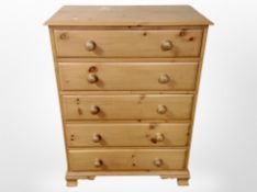 A contemporary pine five drawer chest,