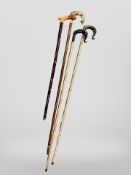 Three carved horn-handled crooks together with a walking stick