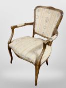 A French beech-framed salon armchair.