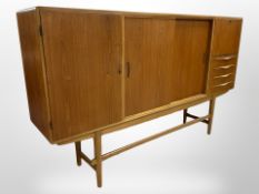 A 1970s Danish teak sliding-door sideboard, 202cm x 43cm x 123cm.