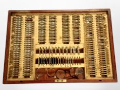 A mahogany tray of optometrist's lenses.
