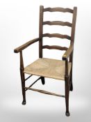 An oak and rattan ladder-back farmhouse armchair, width 54cm.