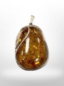 A Baltic amber pendant mounted in white metal, 32.9g, length 62 mm.