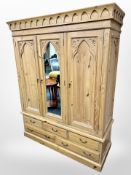 A Gothic style carved pine triple door wardrobe,
