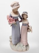 A Lladró figure of two girls carrying flowers.