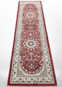 A machine made runner of Persian design,
