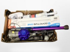 A box containing Dyson stick vacuum cleaner and an Invictus cleaner.