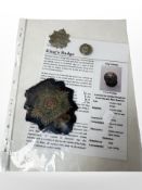 A Border Regiment embroidered shoulder badge, a King's badge, and a Border Regiment cap badge.