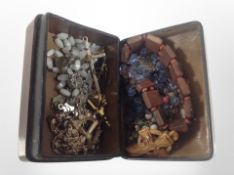 A red tooled Italian trinket box containing assorted costume jewellery, rosary beads, etc.