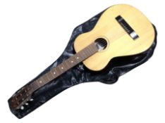 A small acoustic guitar labelled Georgian Foram in interior with soft carry bag