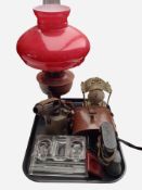 An oil lamp with red glass shade, together with a vintage low lamp, a glass dressing table stand,