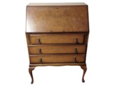 A burr walnut bureau on cabriole legs,