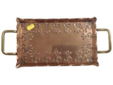 An Arts and Crafts embossed copper and brass twin-handled dressing table tray, width 34cm.