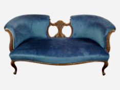 A Victorian carved walnut framed two seater settee in blue upholstery,