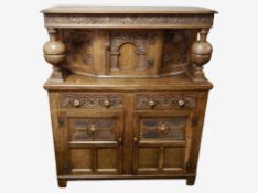 An early 20th century heavily carved oak buffet sideboard,