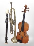 A box of musical instruments including violin, trumpet, two recorders.