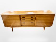 An Alfred Cox teak sliding door low sideboard,
