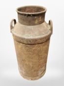 A weathered metal milk churn, height 77cm.