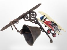 A cast-iron biplane wall-mounted bell on bracket, length from wall 28cm.