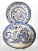 Two 19th-century blue and white willow pattern shallow pedestal bowls, largest 29cm diameter.
