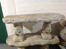 A concrete rustic garden bench on squirrel pedestals, width 100cm.