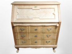 A Danish blond oak serpentine fronted writing bureau,