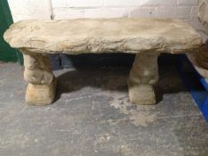 A concrete rustic garden bench on squirrel pedestals, width 100cm.