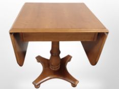 A reproduction drop leaf pedestal table