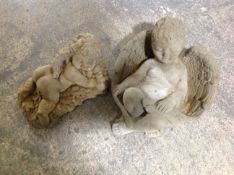 Two concrete garden cherub ornaments, longest 33cm.