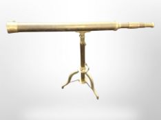 A reproduction brass telescope, 84cm long, on tripod stand.