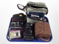 A group of cameras including Olympus Trip 35, Sony Cyber-shot digital camera, Brownie Six-20 camera.