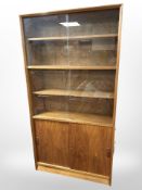 A teak sliding glass door bookcase, 92cm wide x 28cm deep x 173cm high.