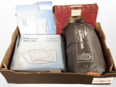 A box containing camping sleeping bag, box set of Christmas-themed Yankee Candles,