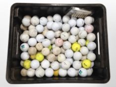 A box containing a large quantity of golf balls.