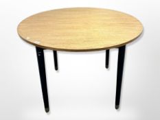 A 20th century oak circular dining table on tapered ebonised legs,