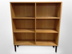 A Scandinavian oak open bookcase, on metal legs,