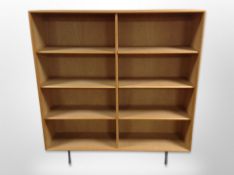 A Swedish oak veneered open bookcase on metal legs, designed by Alf Svensson,