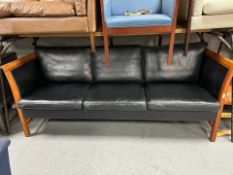 A late 20th century black stitched leather and wooden framed three seater settee,
