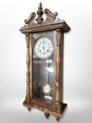 A Hermle oak eight day wall clock with enamelled dial,