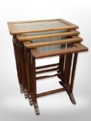 An inlaid mahogany nest of four glass topped tables and a canterbury