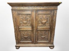 A 19th century Continental carved oak cabinet, on bun feet,