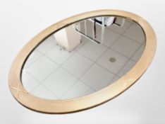 An early 20th century oval gilt framed mirror,