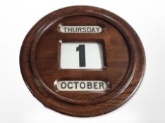 A circular oak scrolling wall calendar,