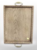 A carved oak serving tray with brass handles,
