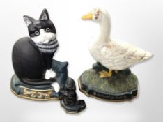 Two painted cast iron cat and duck door stops together with a further Scottie dog example,