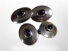 A pair of silver cufflinks with blue oval cabochon stones.