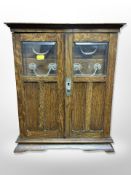A late Victorian oak smoker's cabinet,