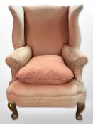 An early 20th century Queen Anne style wingback armchair on carved walnut cabriole legs and another