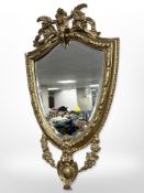 An ornate Period-style shield-shaped gilt mirror, 77cm x 45cm.